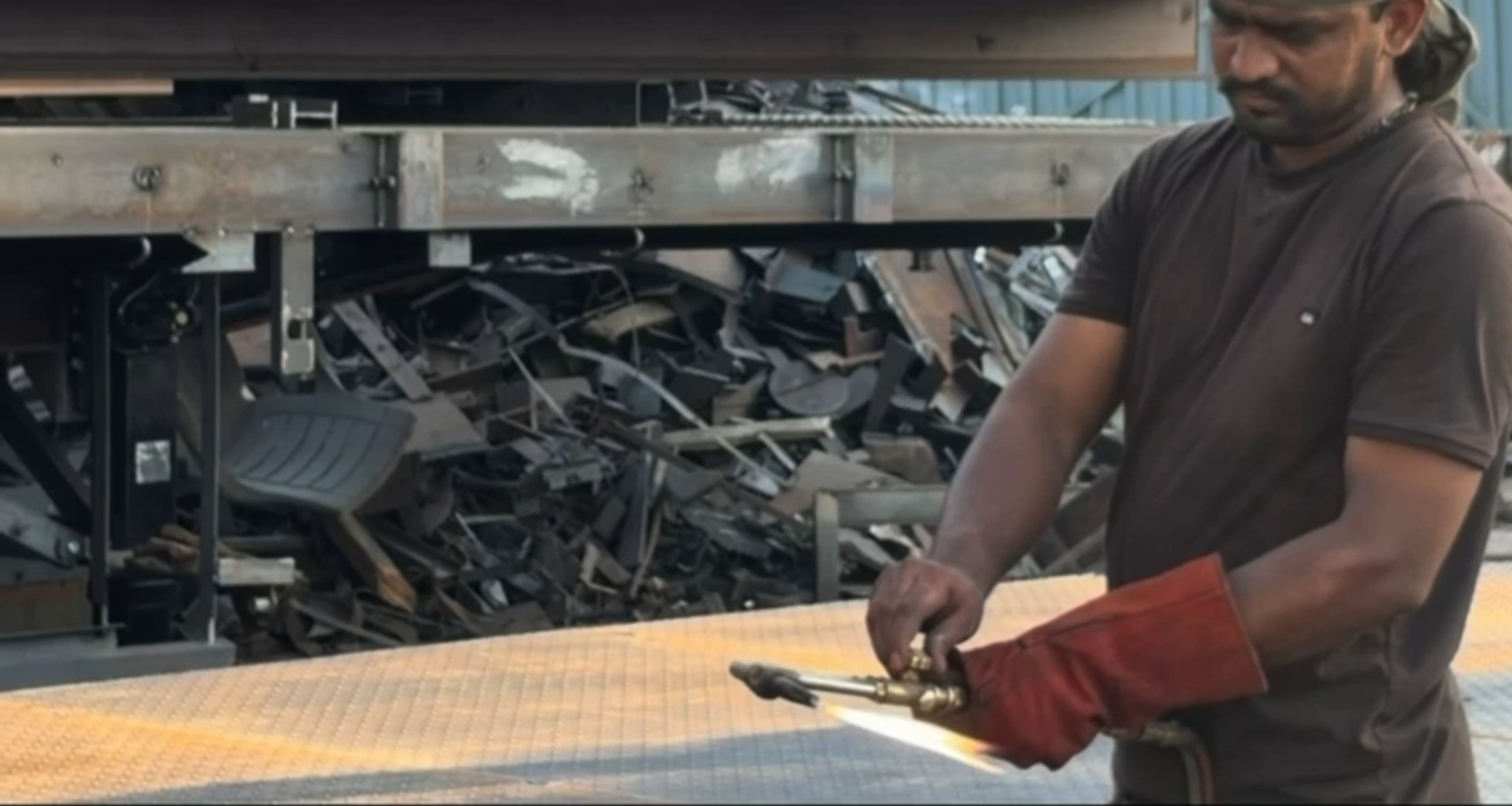 Fabricator torch-cutting a trailer deck plate